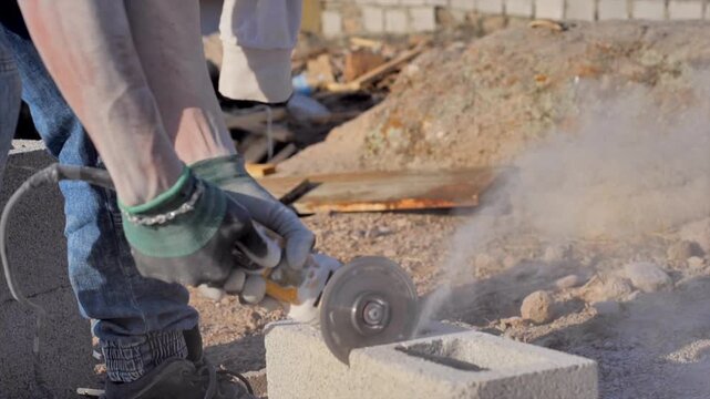 Close-up of a cutting machine splitting a construction brick of a house