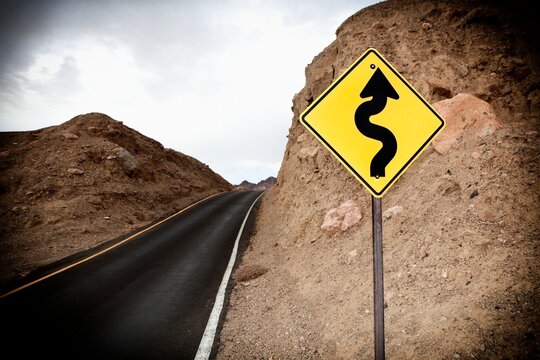 Road and Sign showing winding road ahead, Death Valley National Park, Death Valley, California, USA