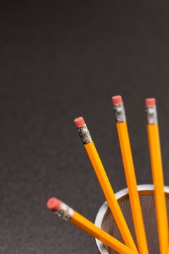Yellow number 2 pencils in cup on desk in business office or school, selective focus