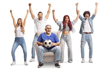 Man sitting in an armchair with a football and cheering with a group of young people