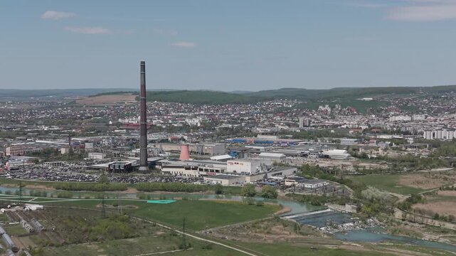 Drone aerial view of Suceava industrial zone near Iulius Mall with factory chimney, river and urban surroundings in Romania
