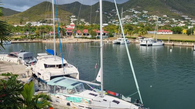 View over Simpson Bay, Sint Maarten, with anchored catamarans and hilly coastline under a dark stormy sky during hurricane season, capturing dramatic tropical weather over the Caribbean