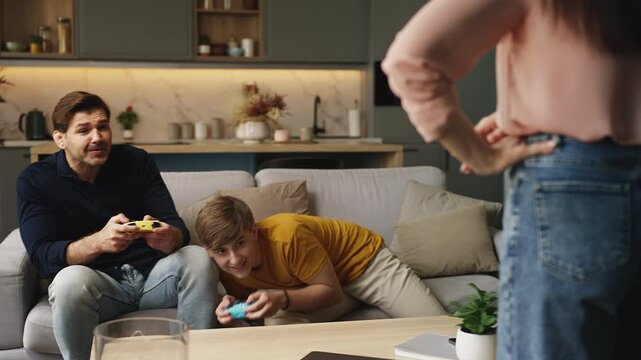 Mom displeased with husband and teen son procrastinating while gaming together