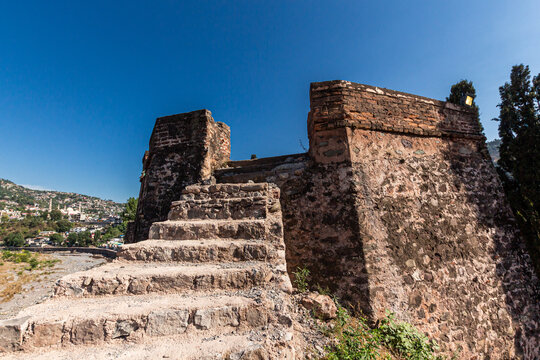 View of Red Fort Muzaffarabad featuring ancient stone stairs leading to a fortified bastion under a clear blue sky with the city in the background Muzaffarabad, Azad Kashmir, Pakistan.