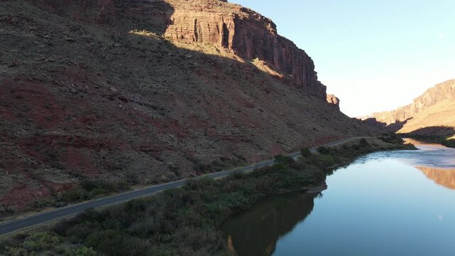Short cinematic drone ascent looking over the Colorado River and red rock canyon walls. Beautiful golden hour lighting. Fast 6-second vertical clip in Full HD 1080p 30fps quality.