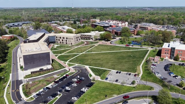 Aerial view of Bowie State University campus in Maryland USA with modern academic buildings, green open lawns, pathways and parking areas in bright spring daylight.