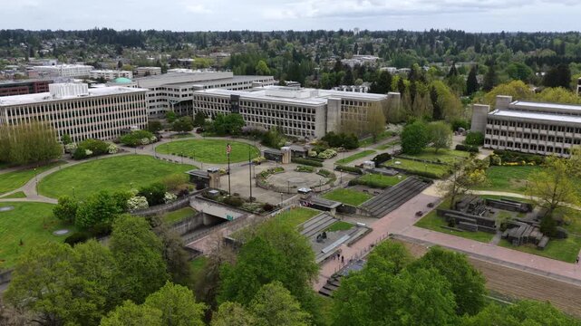 Stately Insurance Building on Washington State Capitol Campus in Olympia, with American and state flags in front of Neoclassical architecture in the USA. Aerial drone approaching shot.