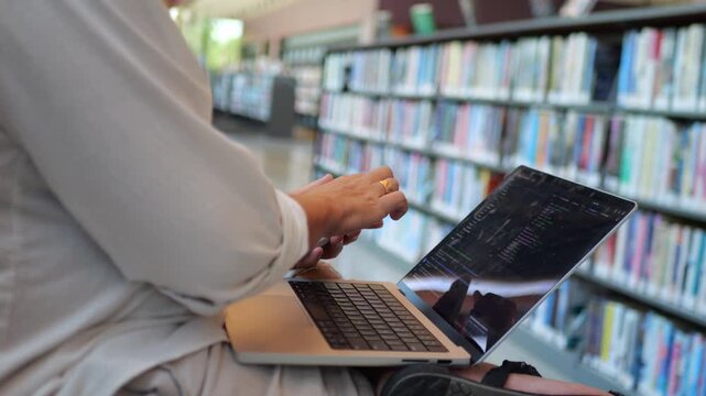 Close-Up of Software Developer Typing Code on Laptop in Library, Modern Programming Workspace Concept