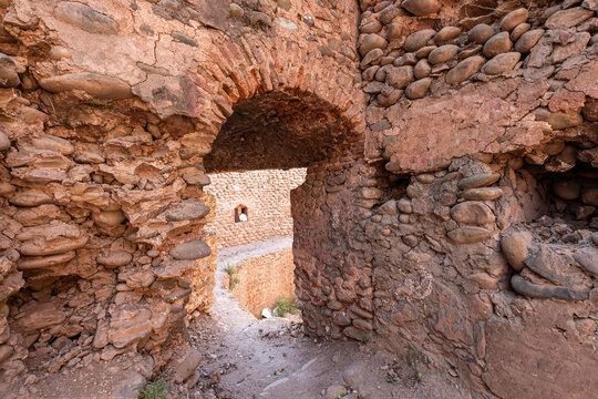 View of the ancient stone archway and crumbling walls of the Red Fort Muzaffarabad with earthy textures and river stones in Muzaffarabad, Azad Kashmir, Pakistan.