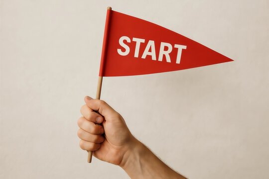 Hand holding small red flag with word start om white background. Beginning of race project business and challenge