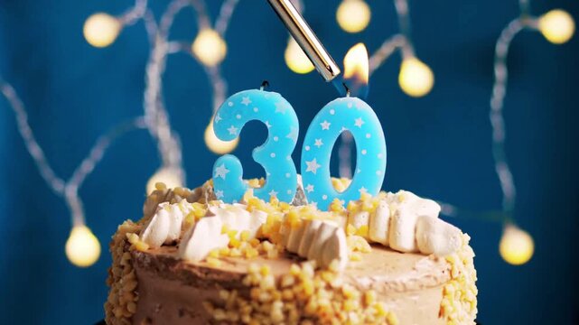 Birthday cake with a 30 number candle placed on a blue background captured in slow motion and close-up view shows a stylish and memorable celebration moment. 