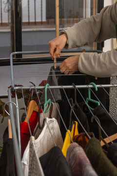 Anonymous hands using clothespin to hang laundry on drying rack