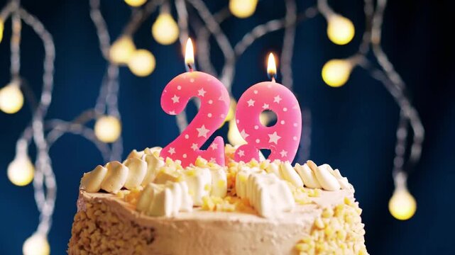 Birthday cake with a 29 pink number candle on a soft pink background captures a beautiful and elegant celebration moment.