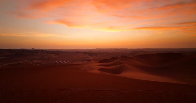 Travel couple stands on dune buggy near Huacachina in Ica desert. Sunset aerial