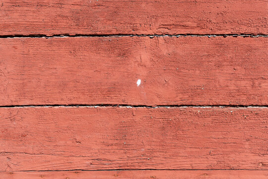 Old barn wood planks with chipped red paint