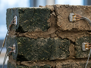 Fototapeta premium Close-up of a bio-brick wall undergoing stress testing, highlighting sensors embedded in the structure