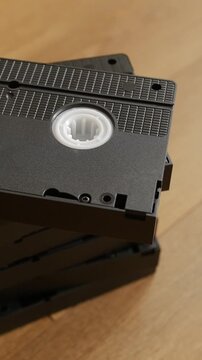 Vertical shot of stacked VHS cassettes on a wood surface