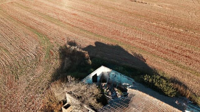 High-Angle Drone Flyover Above Abandoned Stone Building in Harvested Field