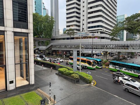Busy urban traffic and street scene with Wisma Cosway building and elevated pedestrian walkway in Bukit Bintang district. Kuala Lumpur, Malaysia, May 2025. 