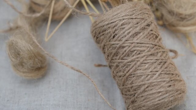 Linen twine and flax fiber on a linen fabric background. Unwinding twine. Natural fiber and eco-textile.