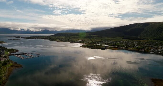 Sunset sky reflection in water and fjord landscape around Stokmarknes, aerial
