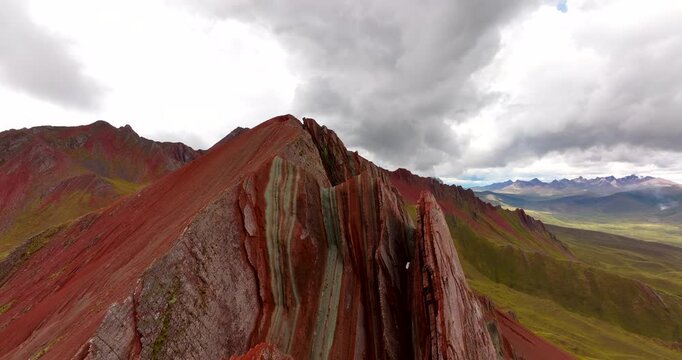 Sharp and colorful sandstone ridges of Pallay Punchu of Apu T'aklla, new Rainbow Mountain in Peru. Aerial forward, copy space