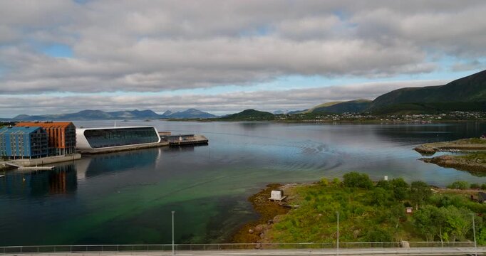 Vehicle drive over bridge with contemporary Hurtigruten museum in back, aerial