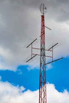 Radio antennae a central metal pole and aerials with a shaped metal skeleton dish at the top.