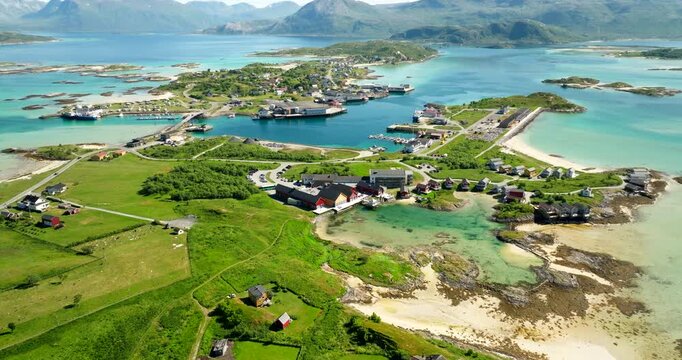 Idyllic summer island with Sommaroy Arctic Hotel on clear lagoon, Norway. Aerial