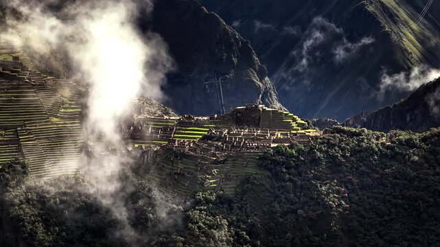 Ancient Inca citadel of Machu Picchu being revealed through moving clouds and fog in Andes mountains, Peru. Aerial drone