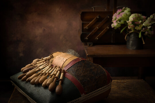 Still life of lace pillow with bobbins