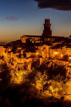 Nighttime view of a town with a clock tower and a steeple, Sovana, Tuscany, Italy, long exposure motion blur