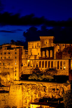 Nighttime view of a city with a clock tower and a clock tower, Sovana, Tuscany, Italy, long exposure motion blur
