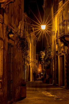 Ghosts, alleyway with a lamp and a lantern at night, Sovana, Tuscany, Italy, long exposure motion blur