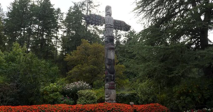 Traditional wood-carved totem pole in Victoria Butchart Gardens,British Columbia,Canada.Totem pole carved in a classic Coast Salish style.