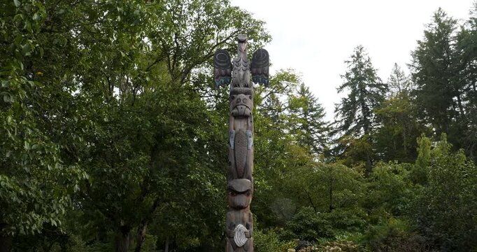 Traditional wood-carved totem pole in Victoria Butchart Gardens,British Columbia,Canada.Totem pole carved in a classic Coast Salish style.