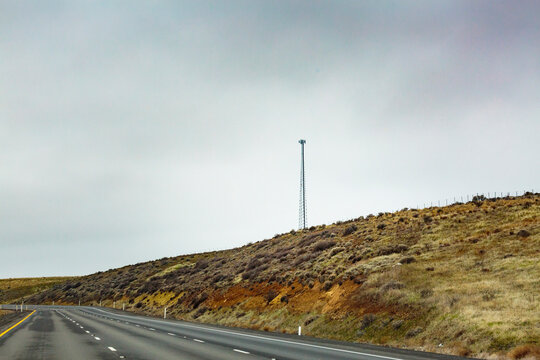 Mobile phone tower in rural desert landscape above Interstate 90
