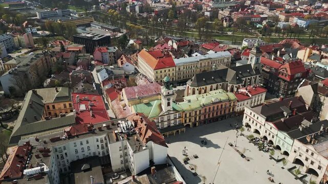 Cinematic aerial drone orbital shot of the historic Town Hall and Market Square in Cieszyn, Poland. Beautiful old town architecture and city life.