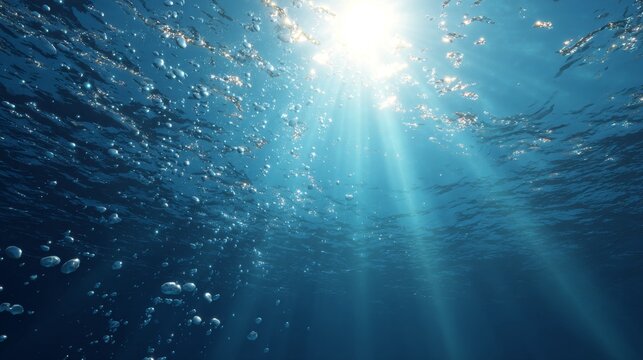 Sunbeams pierce turquoise ocean depths with illuminating rising bubbles.