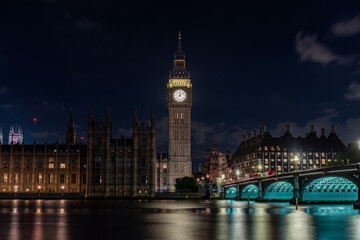 Obraz premium London United Kingdom 00.09 illuminated clock tower riverside government buildings reflection water night skyline historic architecture bridge landmark.