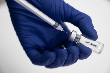 Naklejka premium Hand preparing hantavirus vaccine dose with syringe