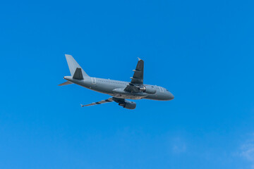 Fototapeta premium Gray military transport plane flying in the blue sky