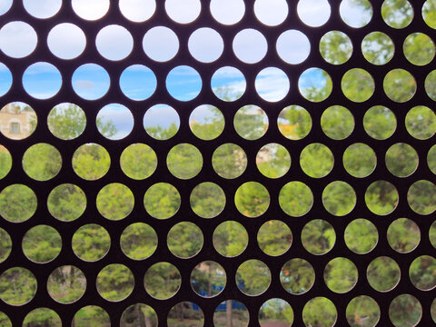 Abstract circular perforated pattern with blurred nature backgro