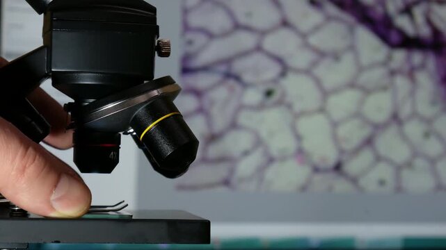 Laboratory Microscope with Digital Cell Image on background Computer Screen