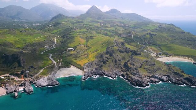 Crete Greece 4k aerial drone panning view of Damnoni Klisidi and Ammoudi beaches near Plakias. Scenic coast with turquoise bays green fields and high mountains background. South Crete travel scenery