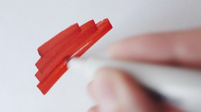 Red marker strokes and hatching cloud with real marker for text overlay on textured white paper close up.