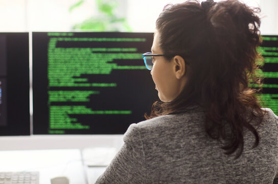 Woman developer programmer coding software on computer. Focused engineer writes clean code on dual monitors in a modern workspace showing technology and productivity. Clear pro dev concept now.