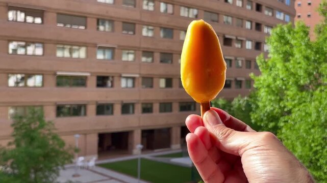 Helado de naranja ice cream con palo polo y hielo delicioso y refrescante en mano para calor de verano orange freezing cold dulce sweet summer