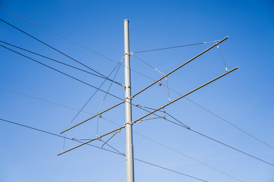 Electrical catenary system for city transit with industrial steel masts and tension wires providing power to electric buses or trams for sustainable urban transportation