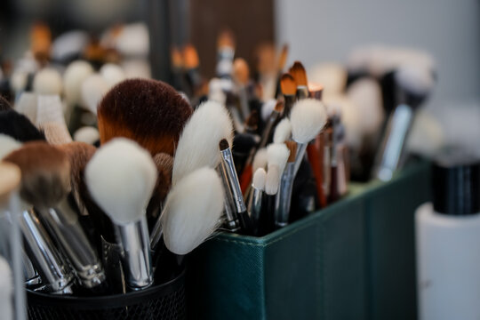 Large set of cosmetic brushes with soft synthetic and natural bristles used by professional makeup artists for face contouring and eye shadow application in a studio